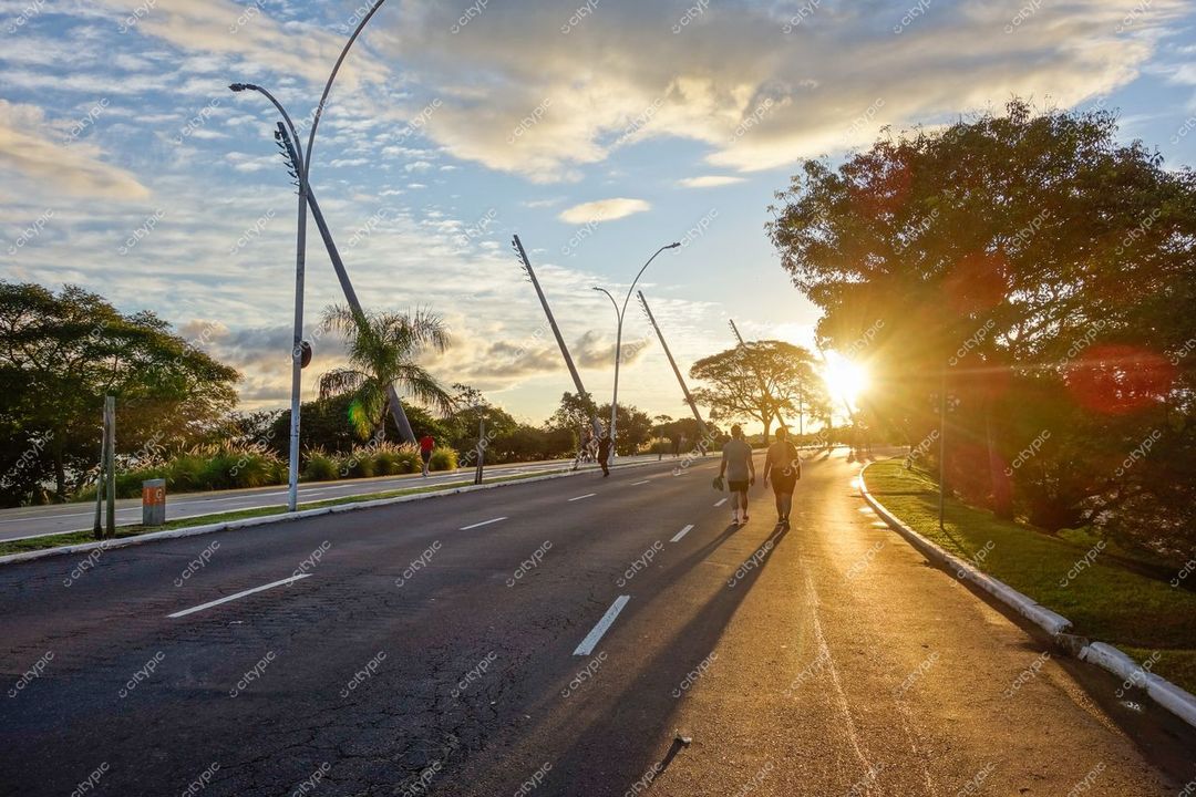 Porto Alegre, Rio Grande do Sul, calçadão tranquilo ao entardecer com sombras longas e árvores frondosas ao fundo