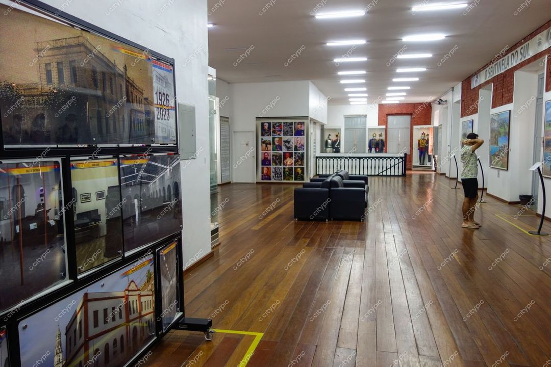 Porto Alegre, Rio Grande do Sul interior de galeria com obras de arte em iluminação artificial e piso de madeira escura