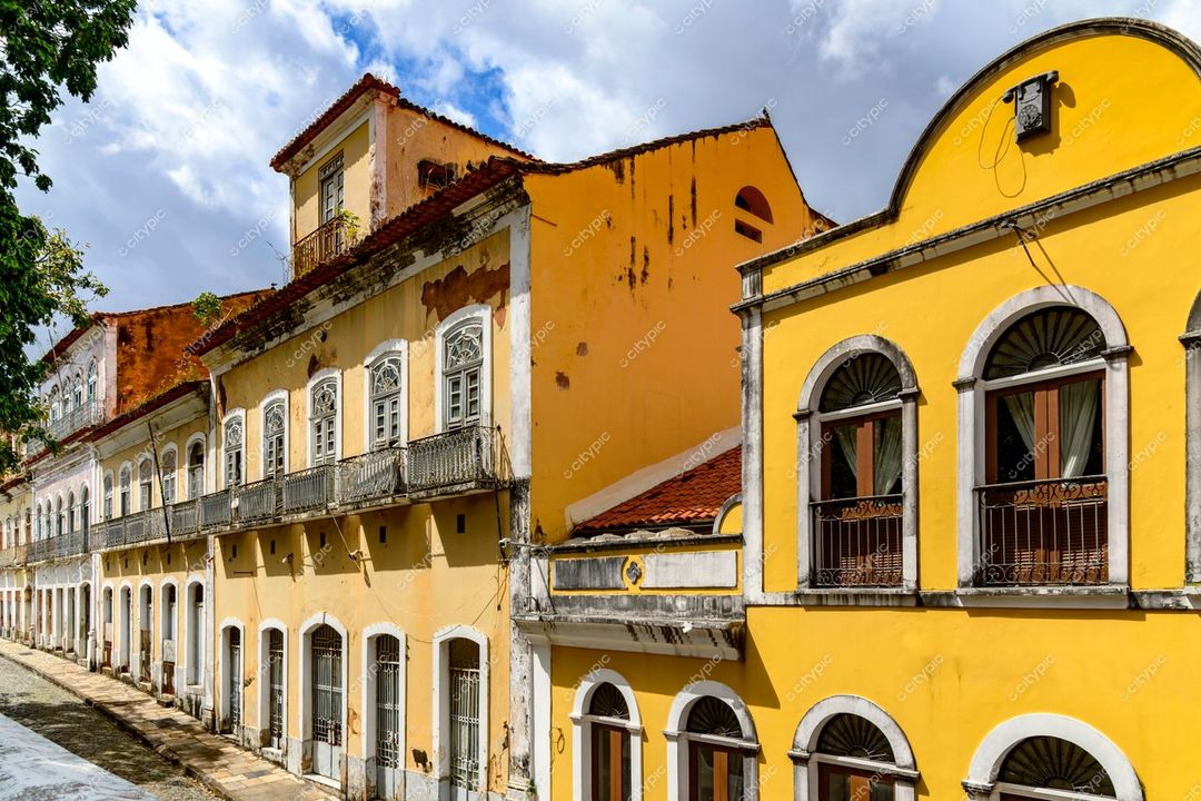 São Luís, Maranhão, rua histórica com arquitetura colonial em tons de amarelo e branco sob céu parcialmente nublado