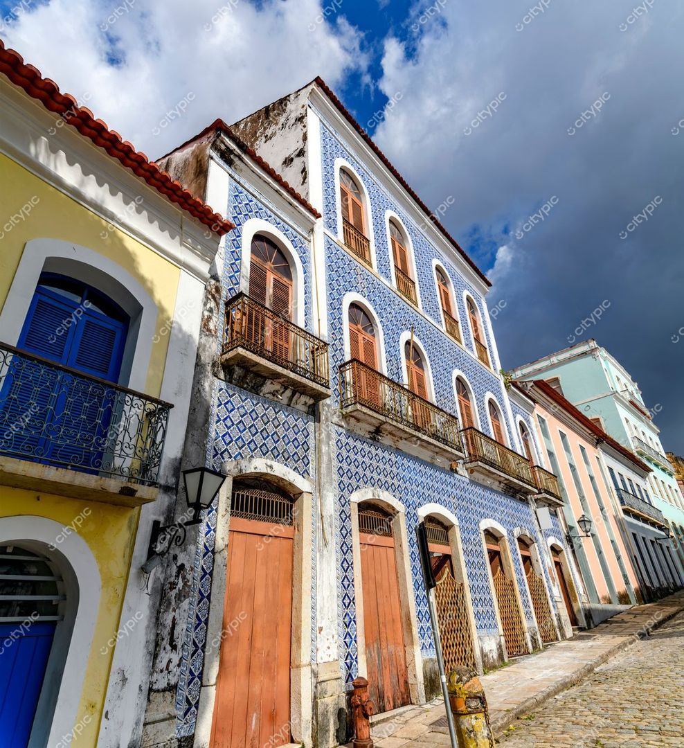 São Luís, Maranhão, rua histórica com edifícios coloniais e azulejos azuis sob céu nublado e calçada de pedra antiga