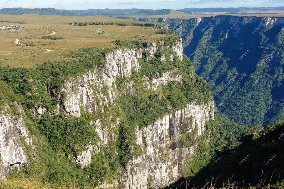 Cambará do Sul, Rio Grande do Sul, desfiladeiro com rochas expostas e vegetação verdejante sob céu ensolarado