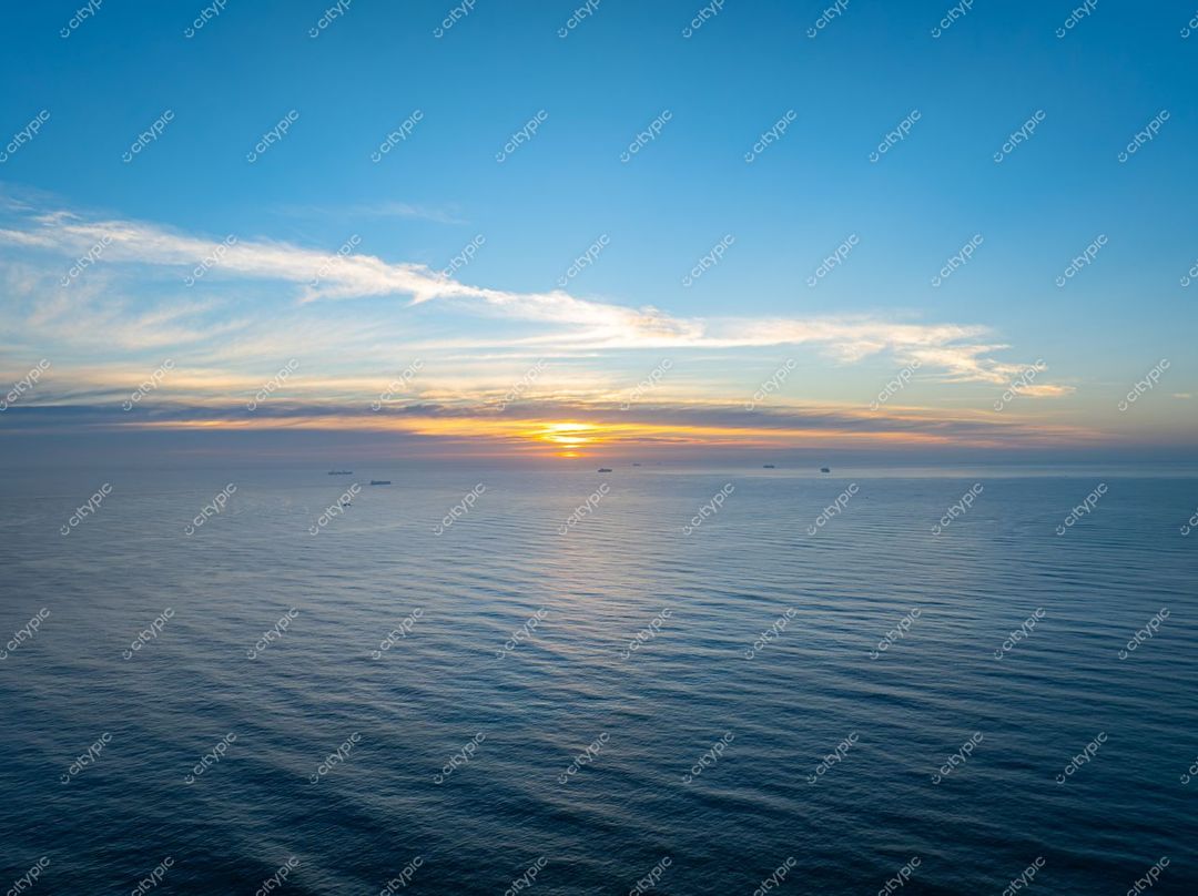 Itajaí, Santa Catarina, pôr do sol tranquilo sobre o oceano com navios ao longe e céu azul e laranja