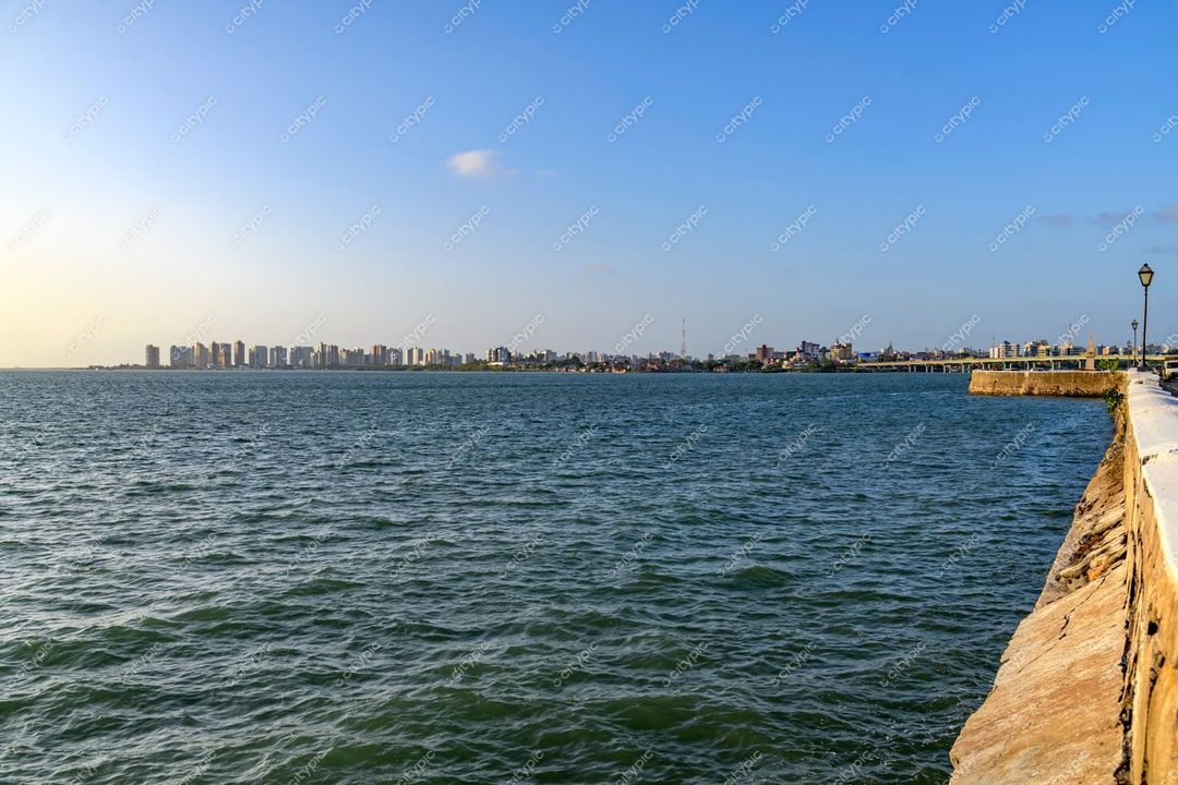 São Luís, Maranhão vista do litoral em dia ensolarado com edifícios ao fundo e mureta de pedra à beira-mar