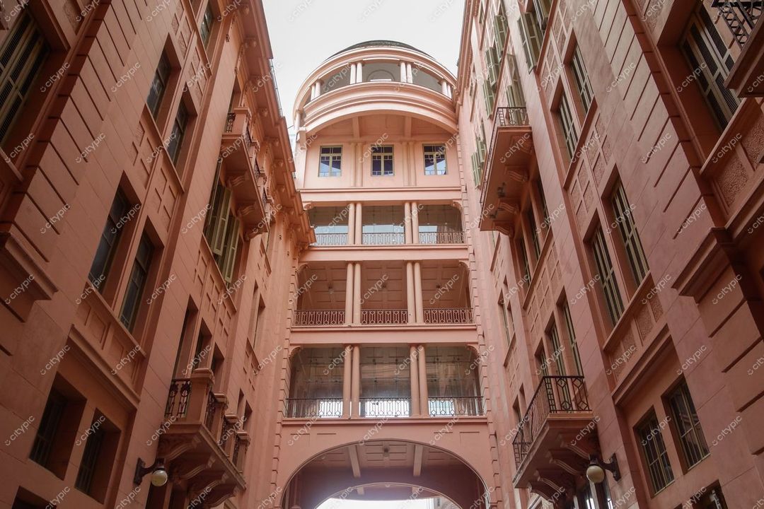 Porto Alegre, Rio Grande do Sul, edifício eclético em tom pastel sob luz diurna com corredor aberto entre construções