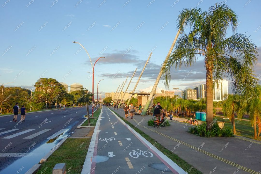 Porto Alegre, Rio Grande do Sul, ciclovia e calçada ao entardecer com palm trees e edificações modernas ao fundo