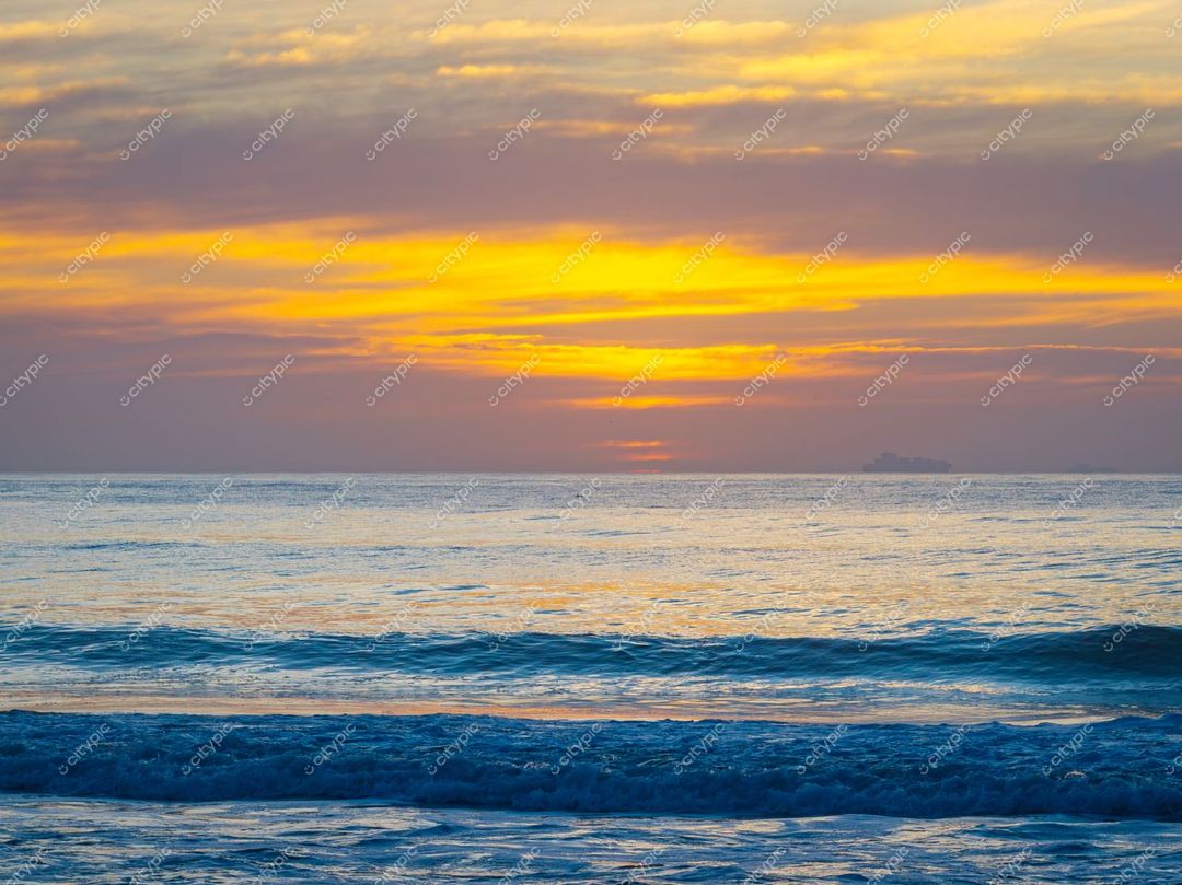 Itajaí, Santa Catarina, pôr do sol sereno sobre o mar com reflexos quentes e embarcação ao longe