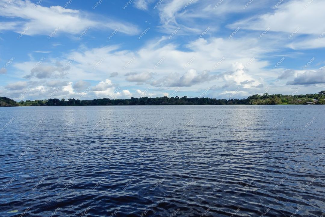 Manaus, Amazonas, corpo d’água refletindo céu nublado com vegetação densa e iluminação natural durante o dia