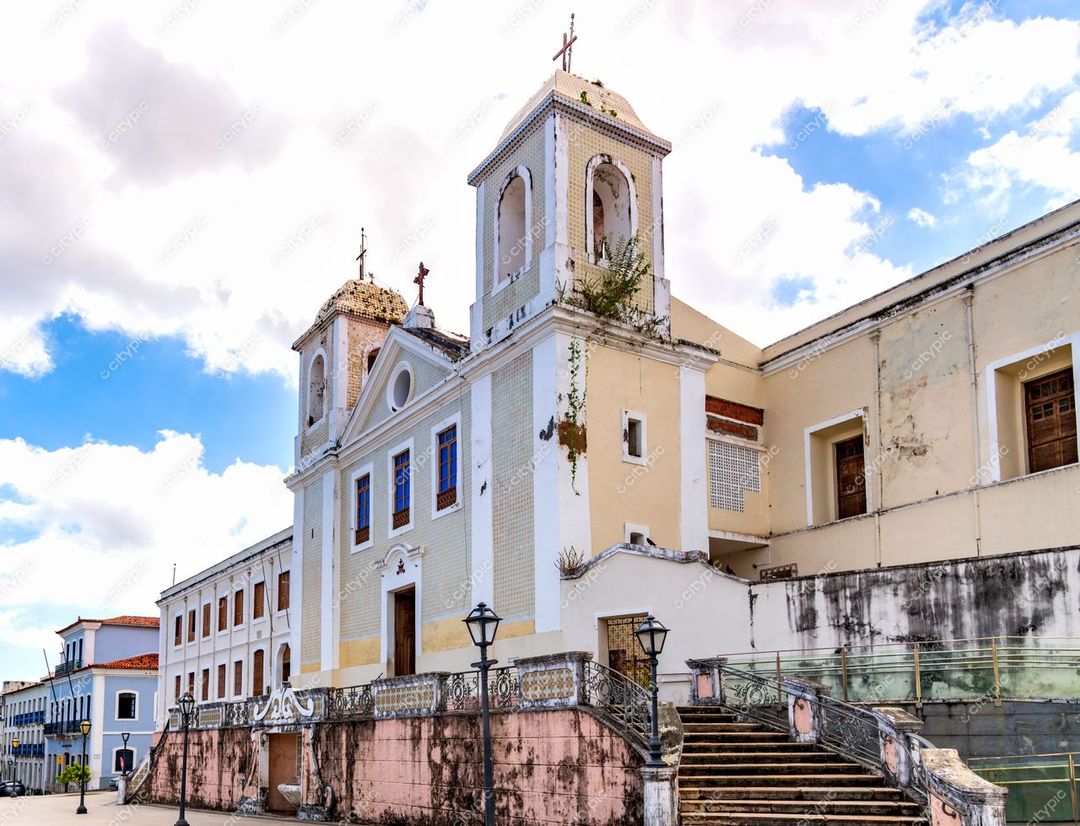 São Luís, Maranhão, arquitetura colonial com igreja de torres e detalhes em pedras sob céu azul e nuvens brancas