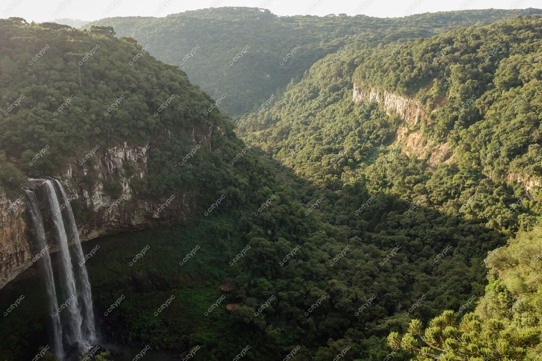 Canela, Rio Grande do Sul, cascata em vale com vegetação densa e relevo montanhoso ao amanhecer