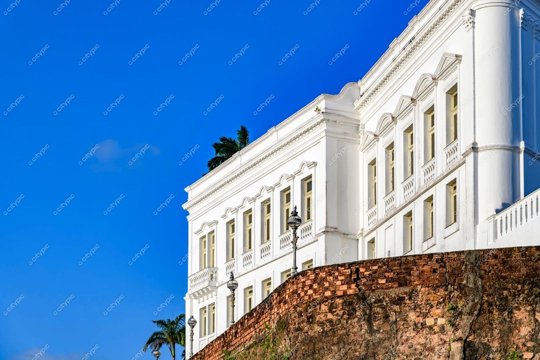 São Luís, Maranhão, edifício histórico colonial com paredes brancas e janelas grandes sob céu azul claro e vegetação tropical