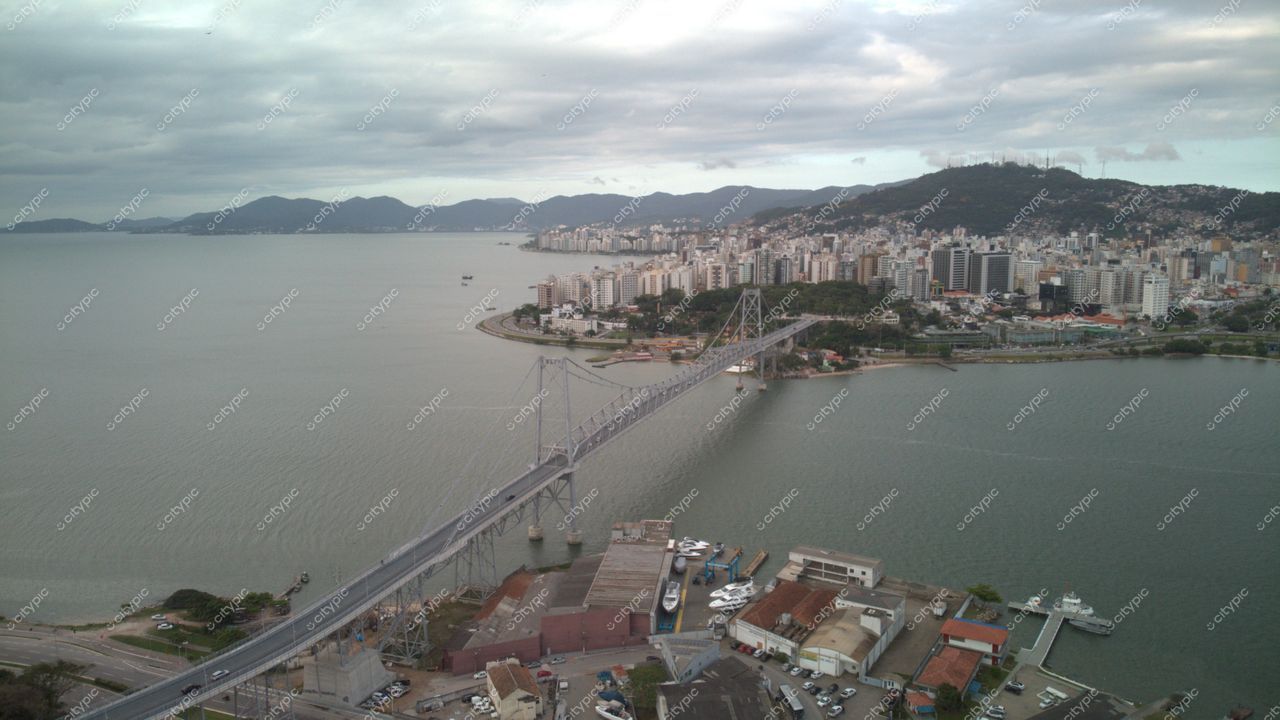 Centro, em Florianópolis com vista panorâmica da Ponte Hercílio Luz e barcos ancorados sob céu nublado