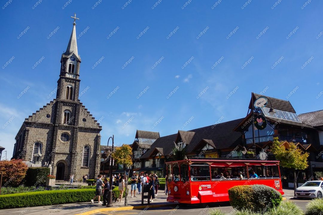 Gramado, Rio Grande do Sul, igreja gótica e edifício europeu com bonde vermelho em dia ensolarado e vegetação