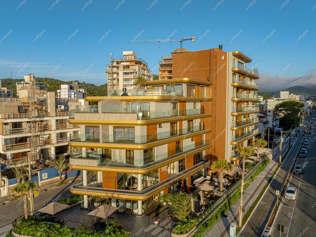 Itajaí, Santa Catarina moderno edifício com fachada em creme e laranja em dia ensolarado e vegetação ornamental ao redor