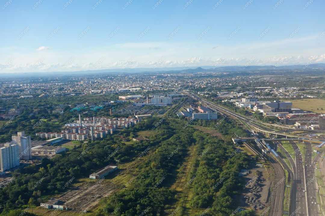 Porto Alegre, Rio Grande do Sul vista aérea com vegetação ao redor e montanhas ao fundo em dia claro