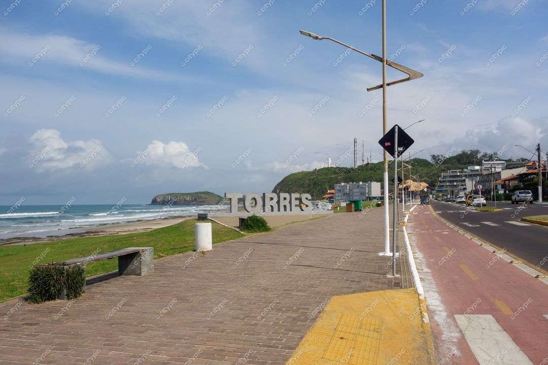Torres, Rio Grande do Sul com letreiro destacado e calçada à beira-mar em dia ensolarado e tranquilo