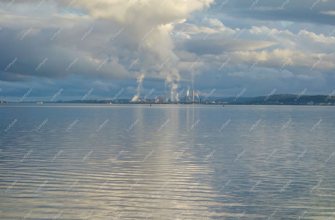 Porto Alegre, Rio Grande do Sul com chaminés industriais ao fundo e céu nublado durante o crepúsculo urbano