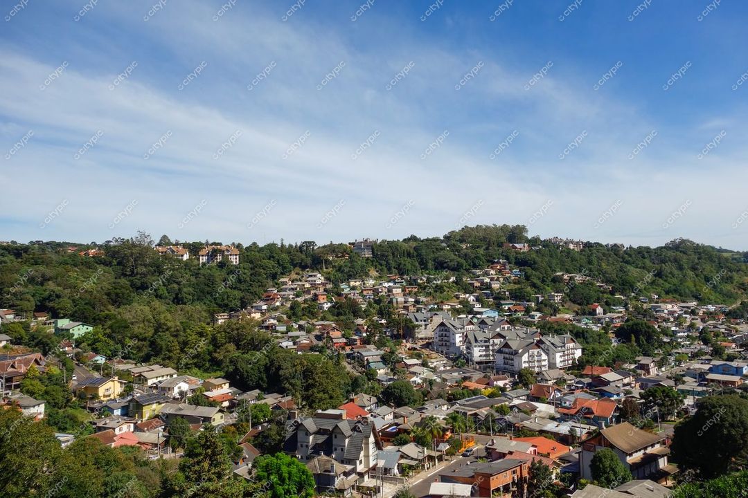 Gramado, Rio Grande do Sul em dia ensolarado com casas coloridas e vegetação densa em relevo montanhoso