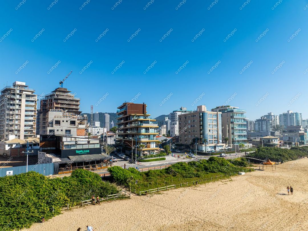 Itajaí, Santa Catarina vista urbana com céu azul e edifícios modernos em construção próximos à praia e vegetação rasteira