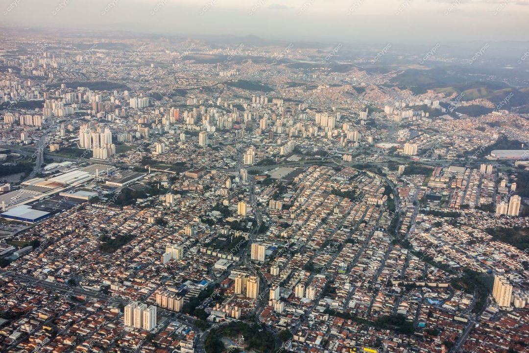 São Paulo, São Paulo, vista aérea ao entardecer com reflexos do sol em prédios e bairros residenciais definidos