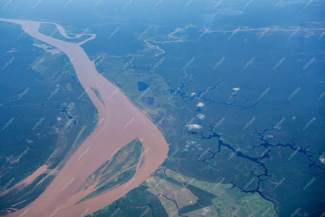 Manaus, Amazonas, vista aérea com cursos d’água sinuosos e vegetação tropical em dia claro e céu azul