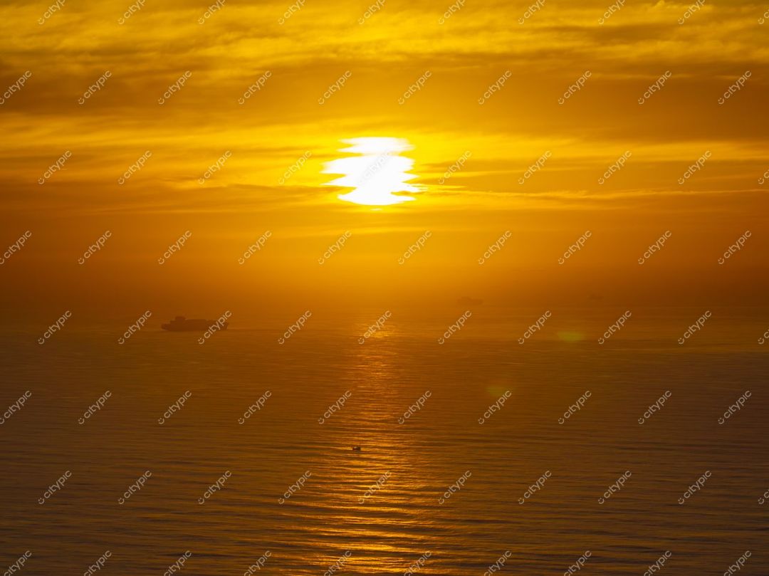 Itajaí, Santa Catarina, pôr do sol com tonalidades quentes refletindo no mar e embarcações ao fundo