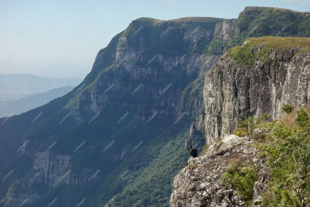 Cambará do Sul, Rio Grande do Sul, formação montanhosa com vegetação rasteira e personagem humano para escala em dia ensolarado